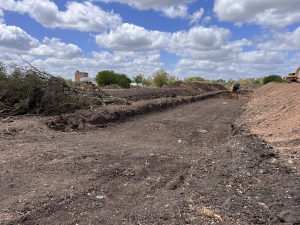 Retroexcavadora limpiando y desparramando tierra La Posta de Pilar